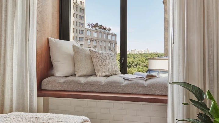 A cushioned window seat framing the greenery of Central Park
