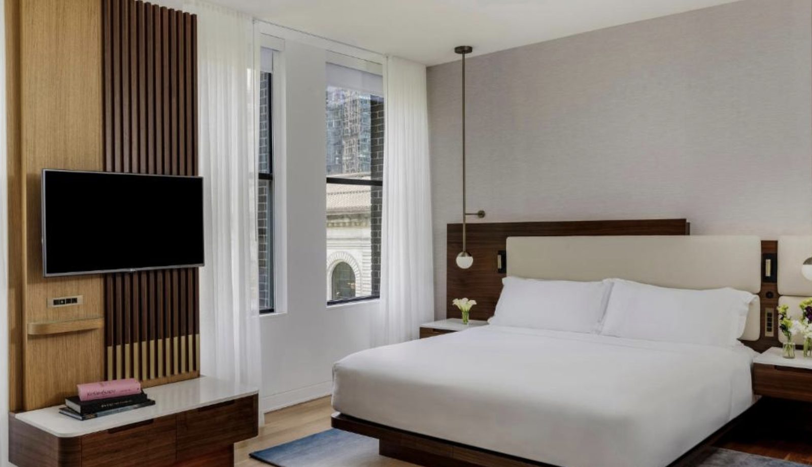 A guest room with walnut detailing and Midtown views