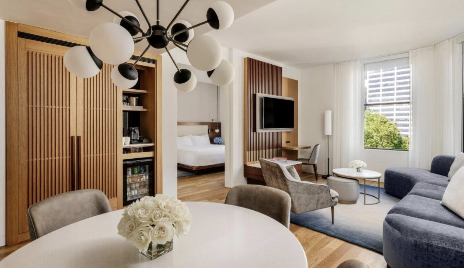 A suite living room at The Bryant Park Hotel, with bedroom beyond