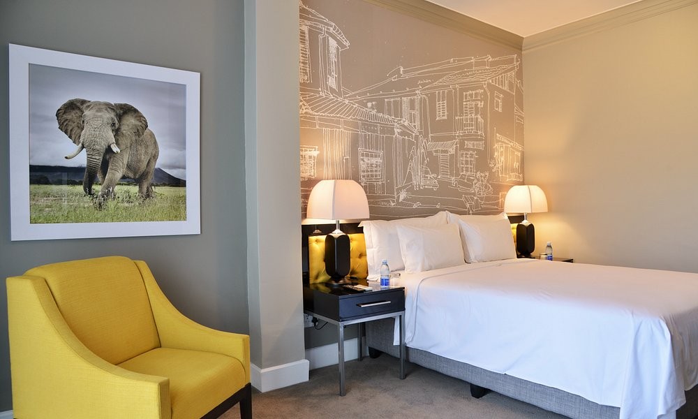 A guest room at The Capetonian, with elephant photography above a yellow armchair