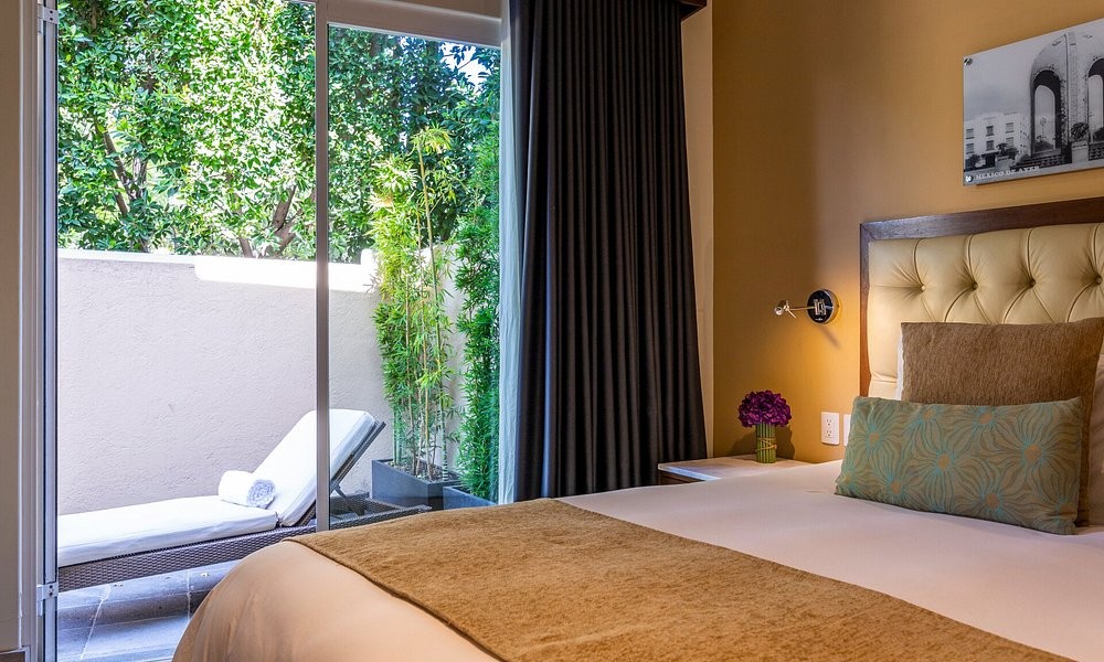 A guest room at Casa Malí by Dominion, opening onto a private planted patio