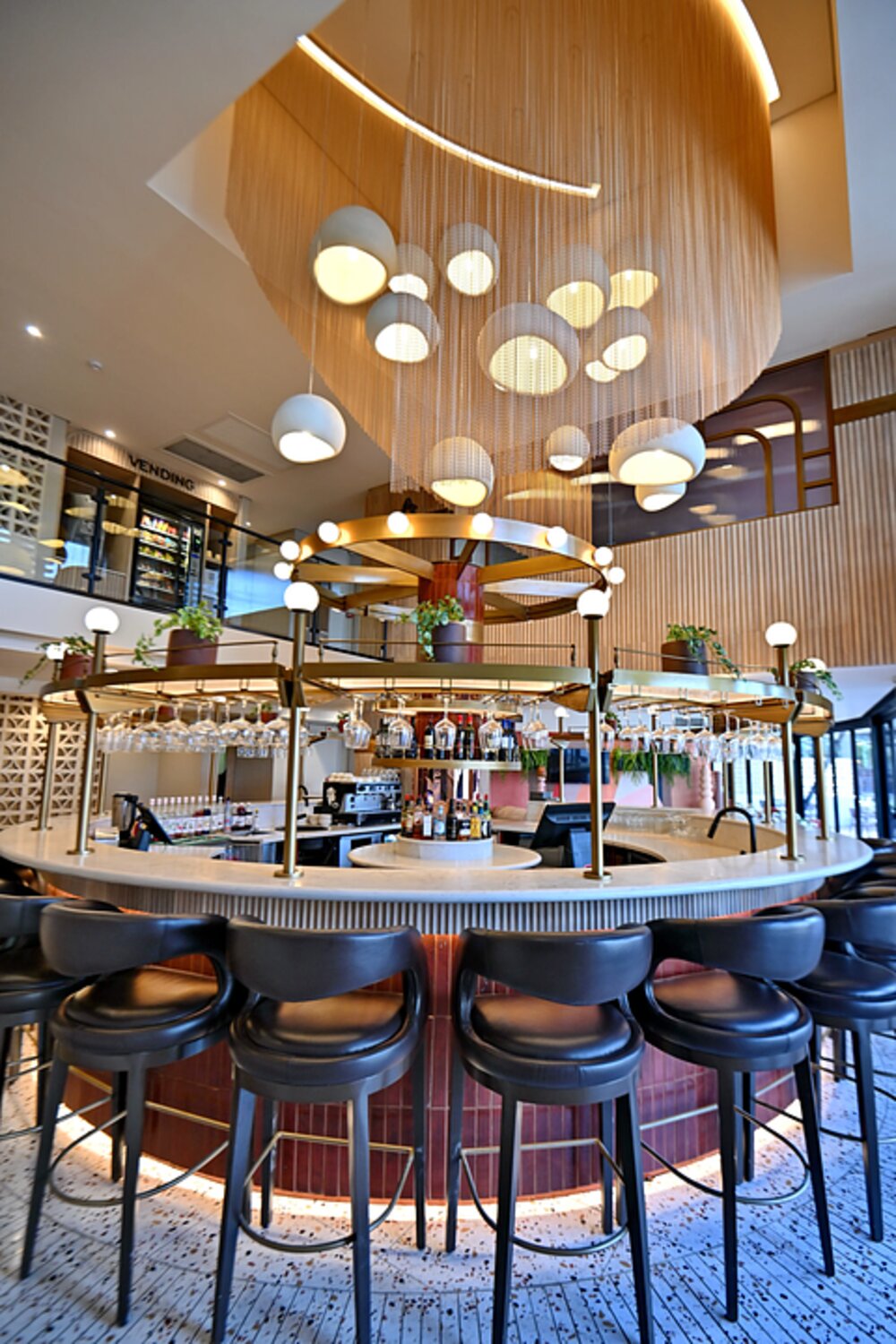 The circular hotel bar beneath a sculptural pendant light installation