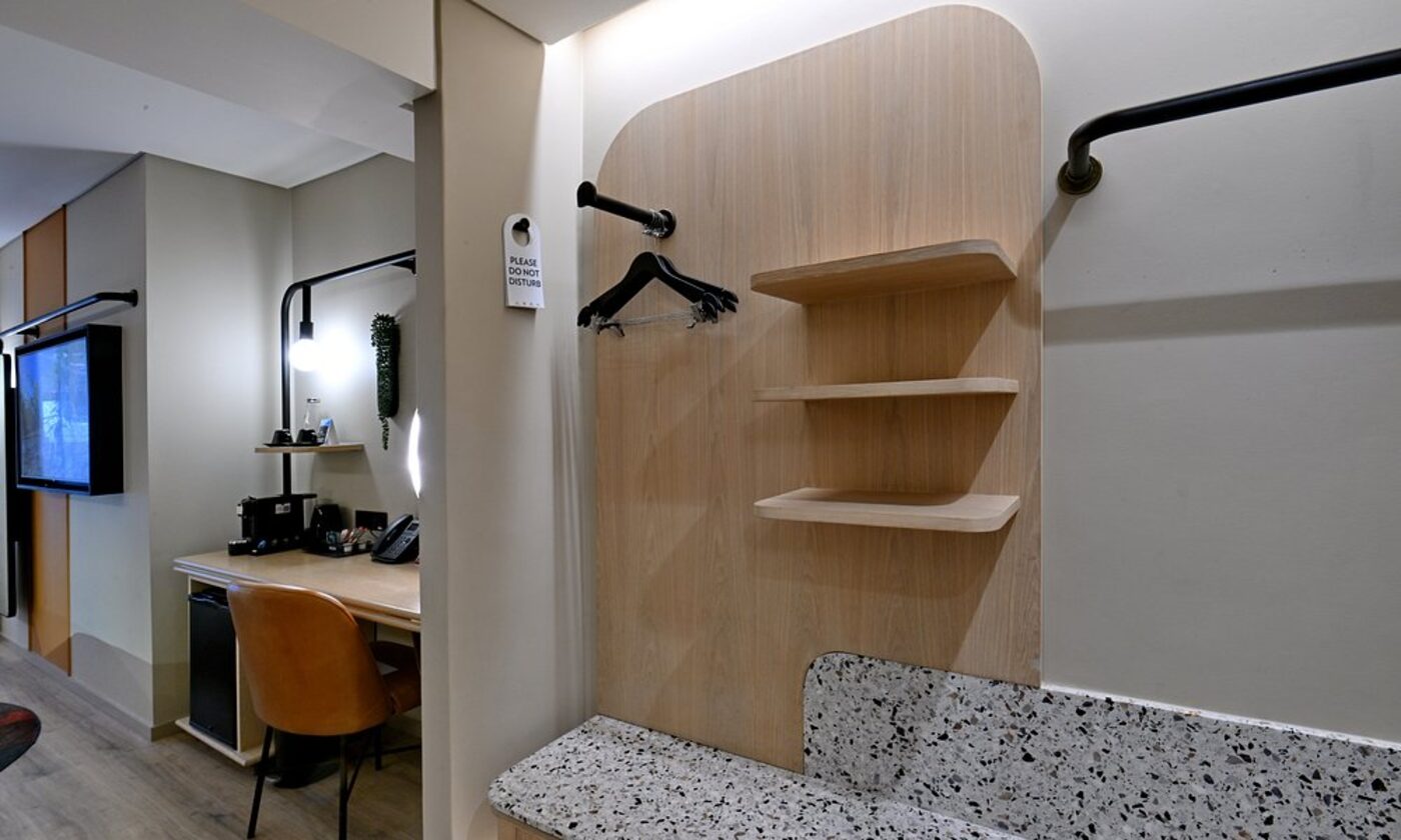 A wardrobe nook with wooden shelving in a guest room