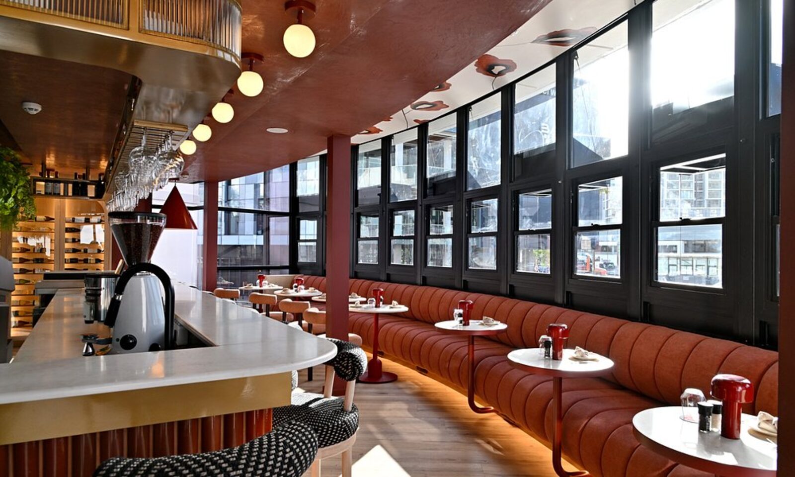 The hotel restaurant, with curved terracotta booths beneath large windows