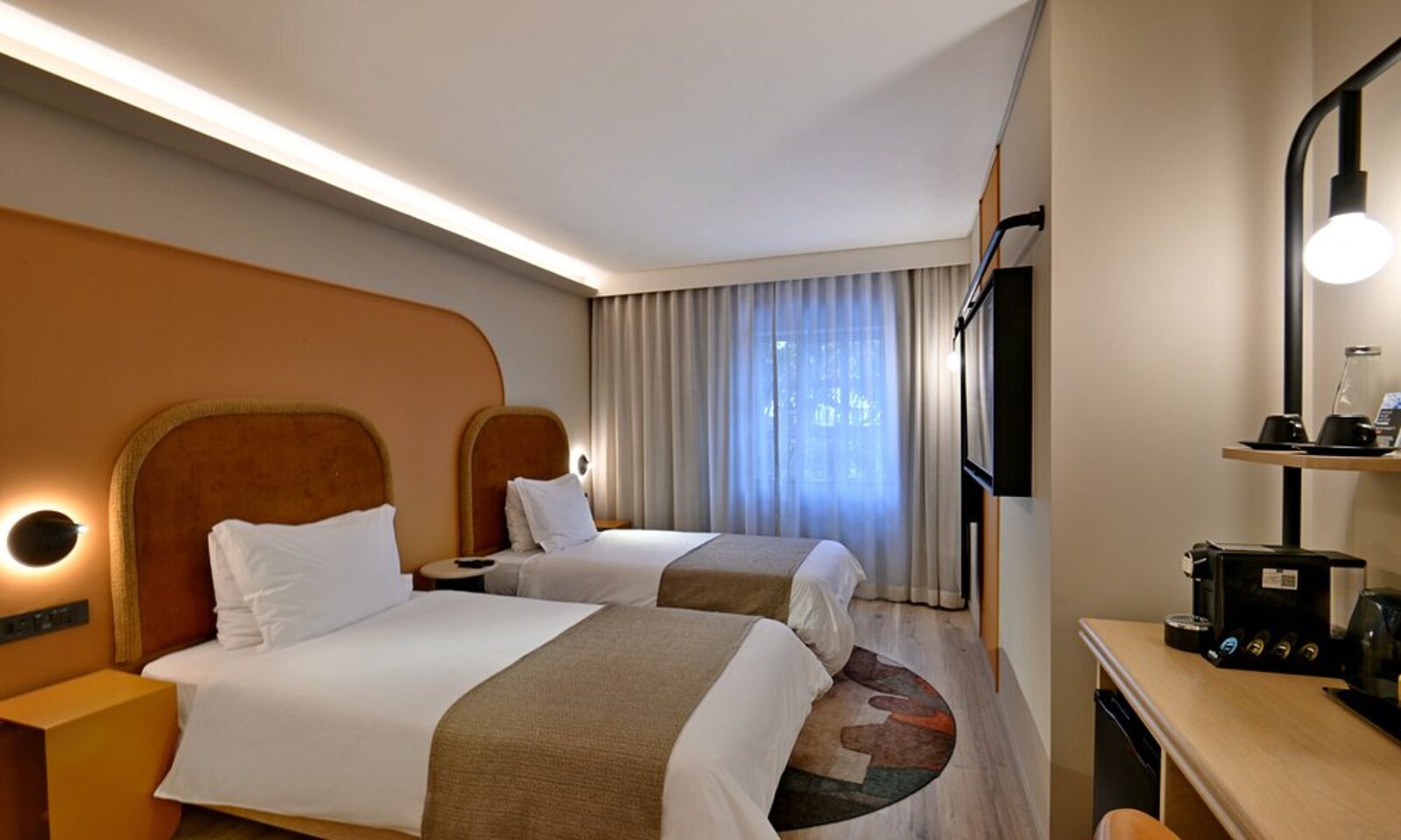 A twin room at City Lodge Hotel V&A Waterfront, with curved orange headboards