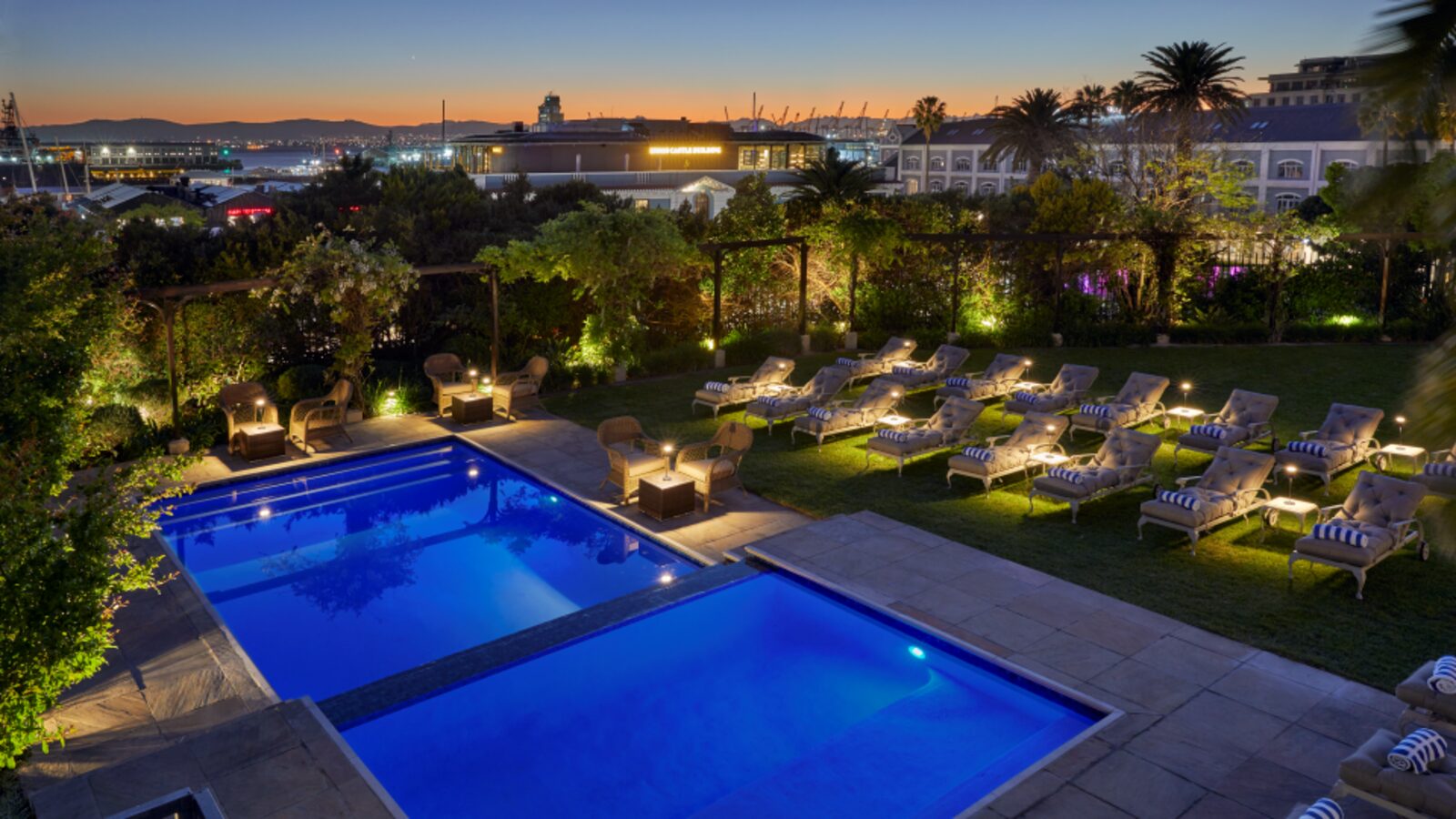 The pool at dusk, with the V&A Waterfront and harbour lights beyond