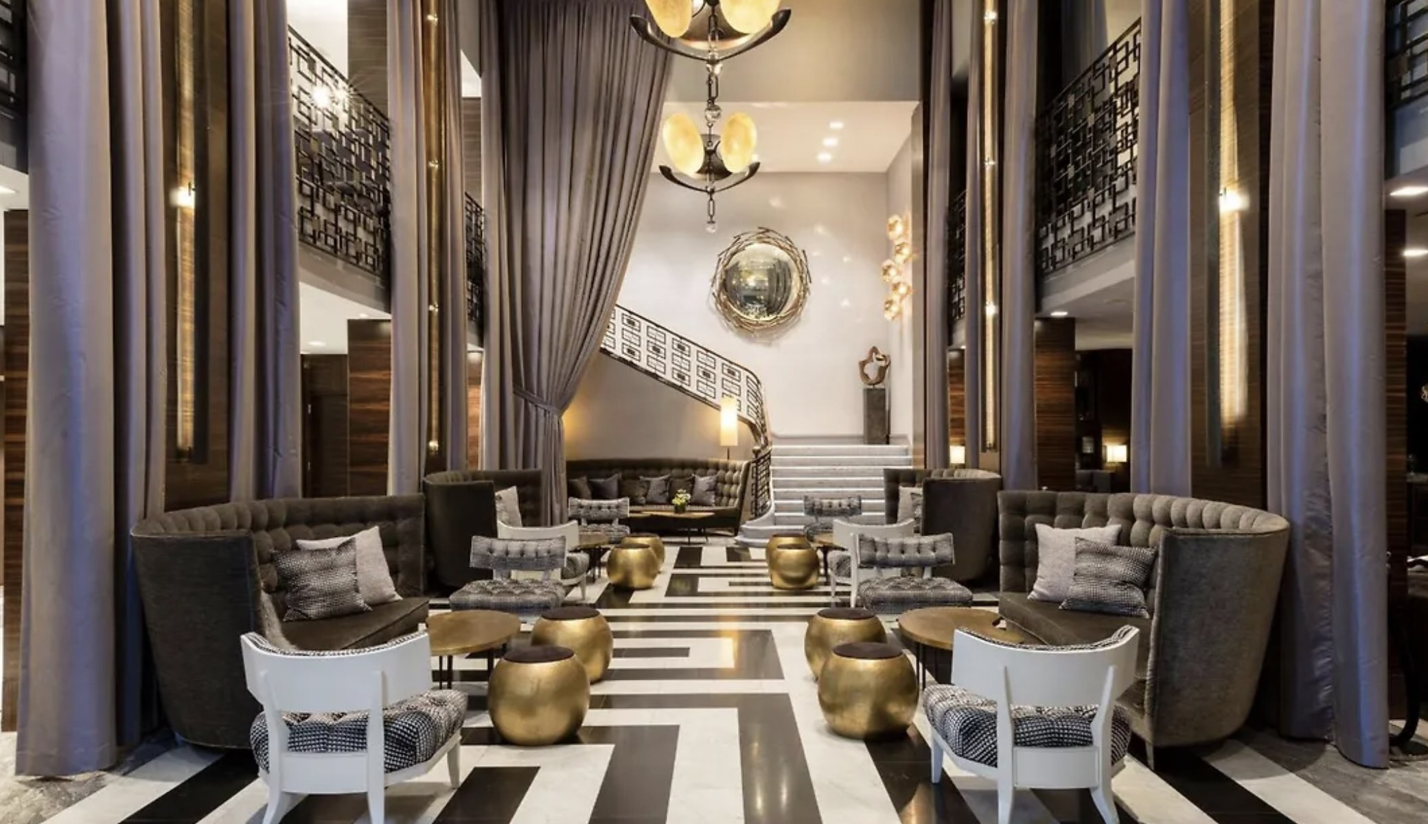 The Empire Hotel's lobby lounge, with sweeping staircase and brass drum tables