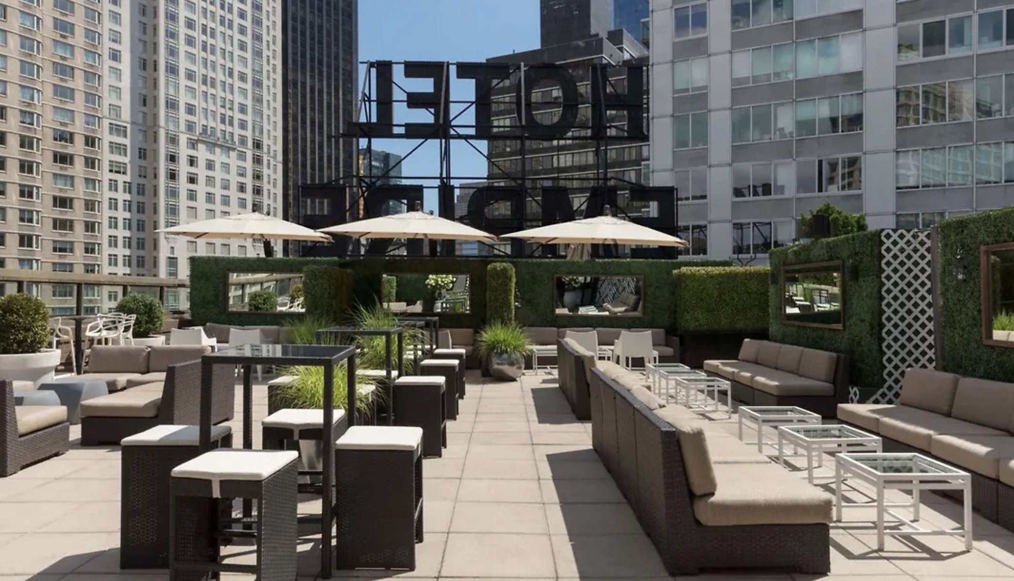 The Empire Hotel's rooftop lounge terrace by day, hedged and screened above Midtown