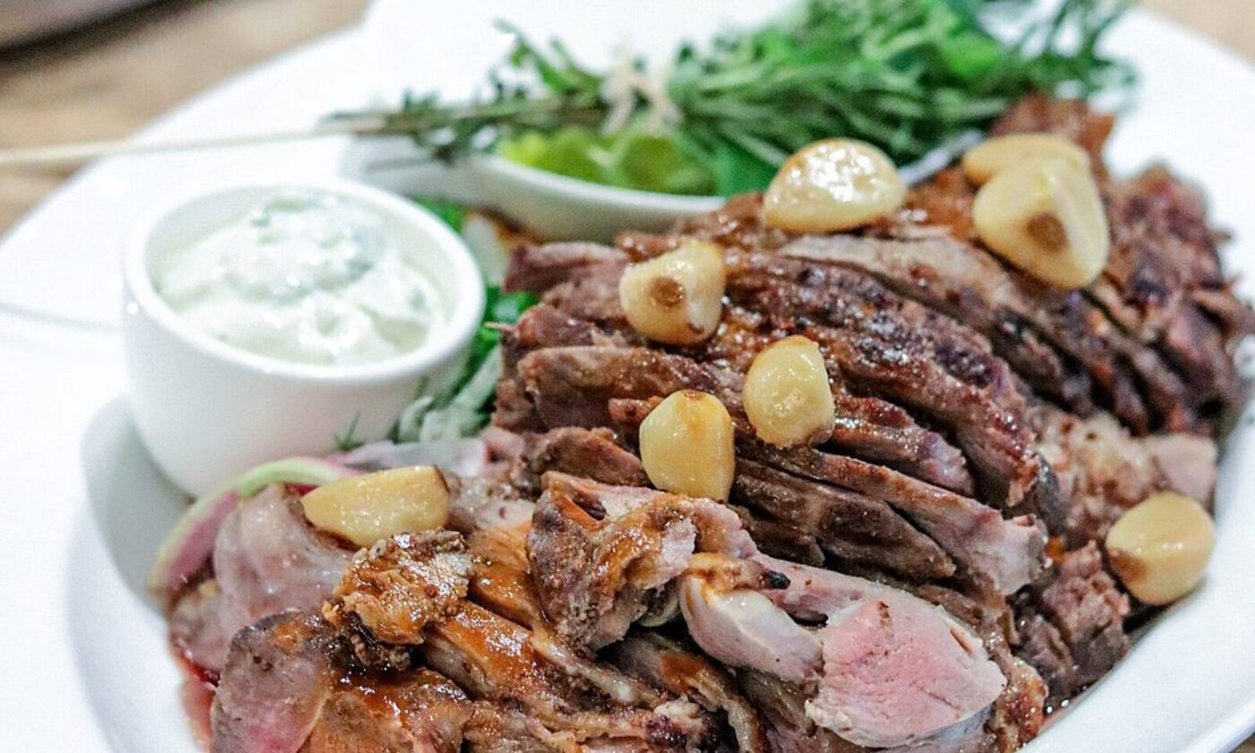 A carved lamb roast with garlic and herbs