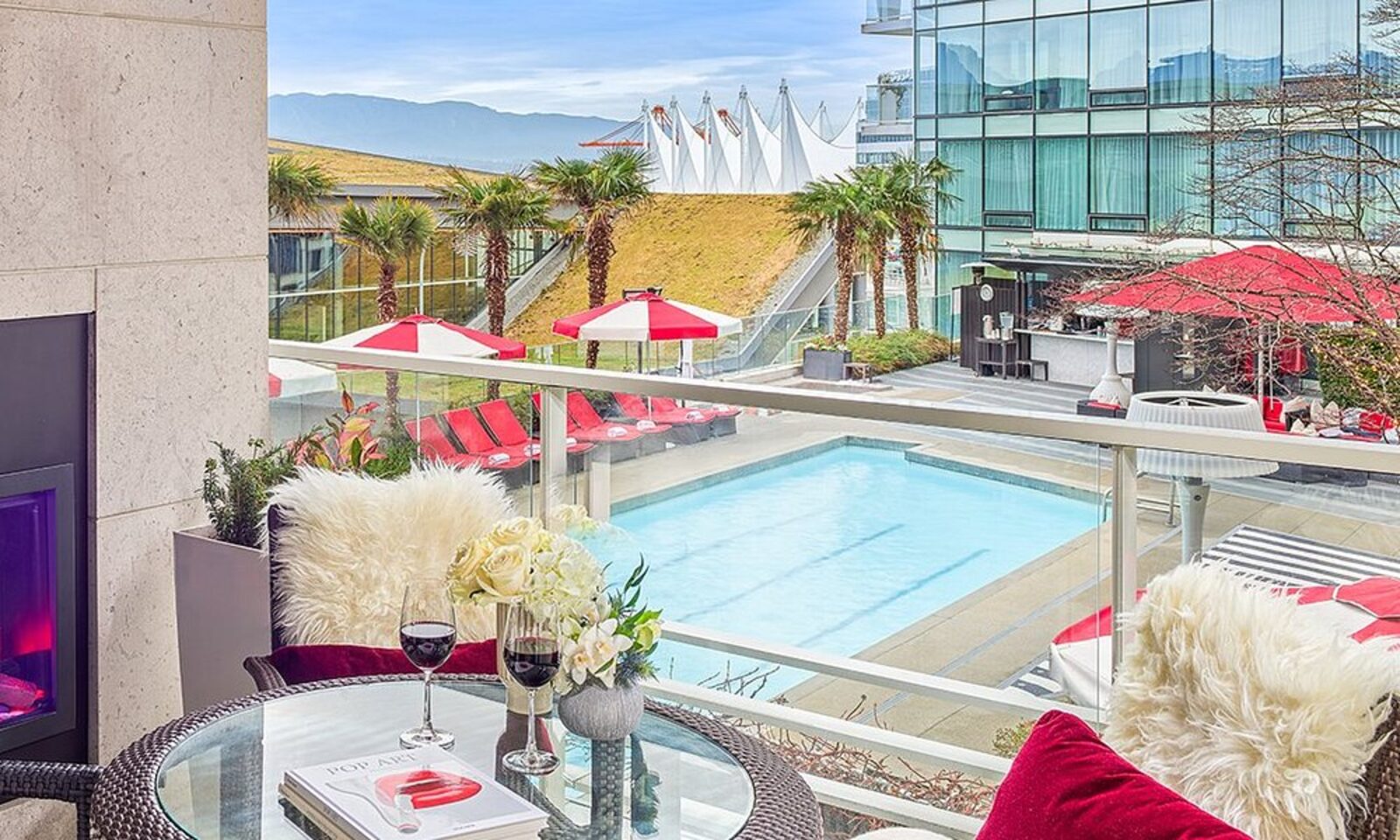 A balcony view over the hotel pool toward Canada Place's white sail roofs