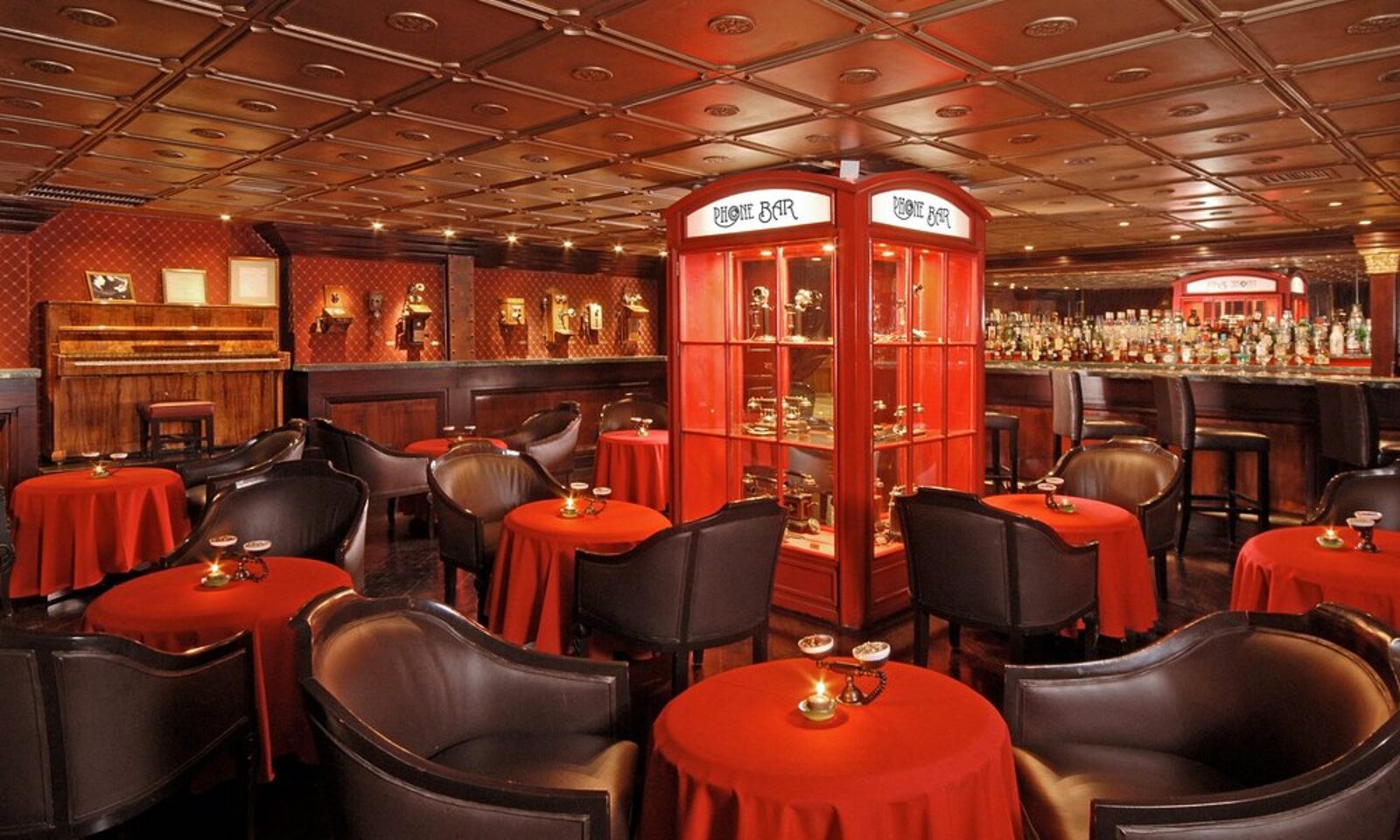 The hotel's Phone Bar, with red leather chairs and a vintage telephone display case