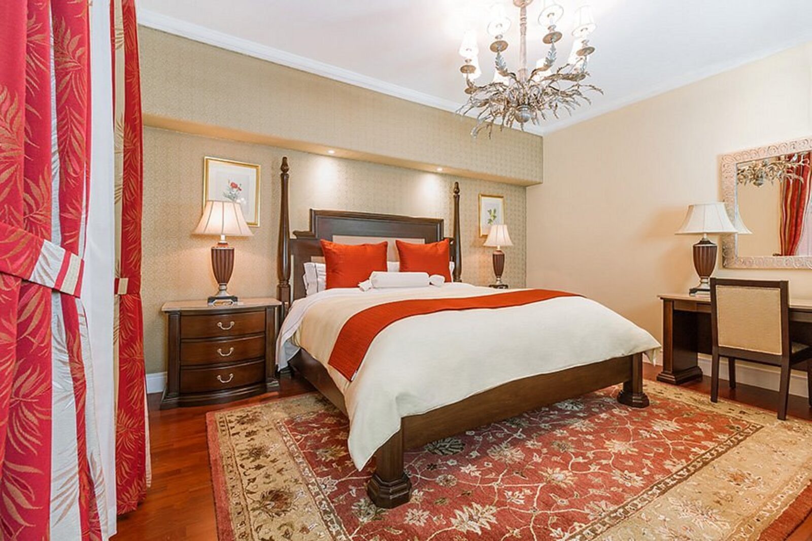 A room at Hotel Geneve with a four-poster bed, chandelier and period furnishings