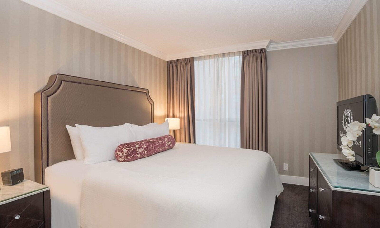 A bedroom at La Grande Résidence with a branded Sutton Place television