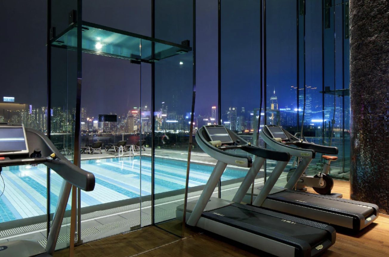 The pool and gym, glass-walled to the night skyline