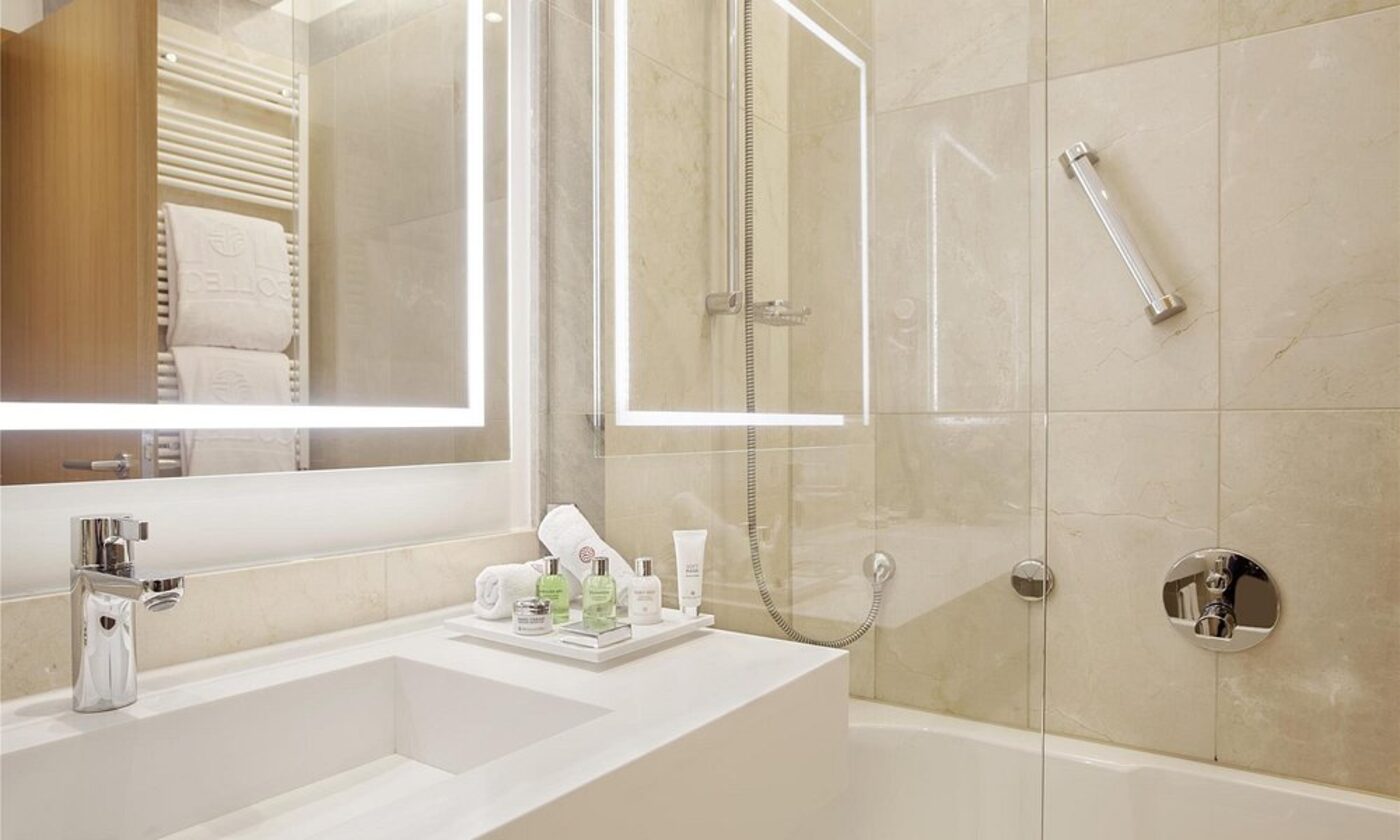 A marble bathroom with walk-in shower