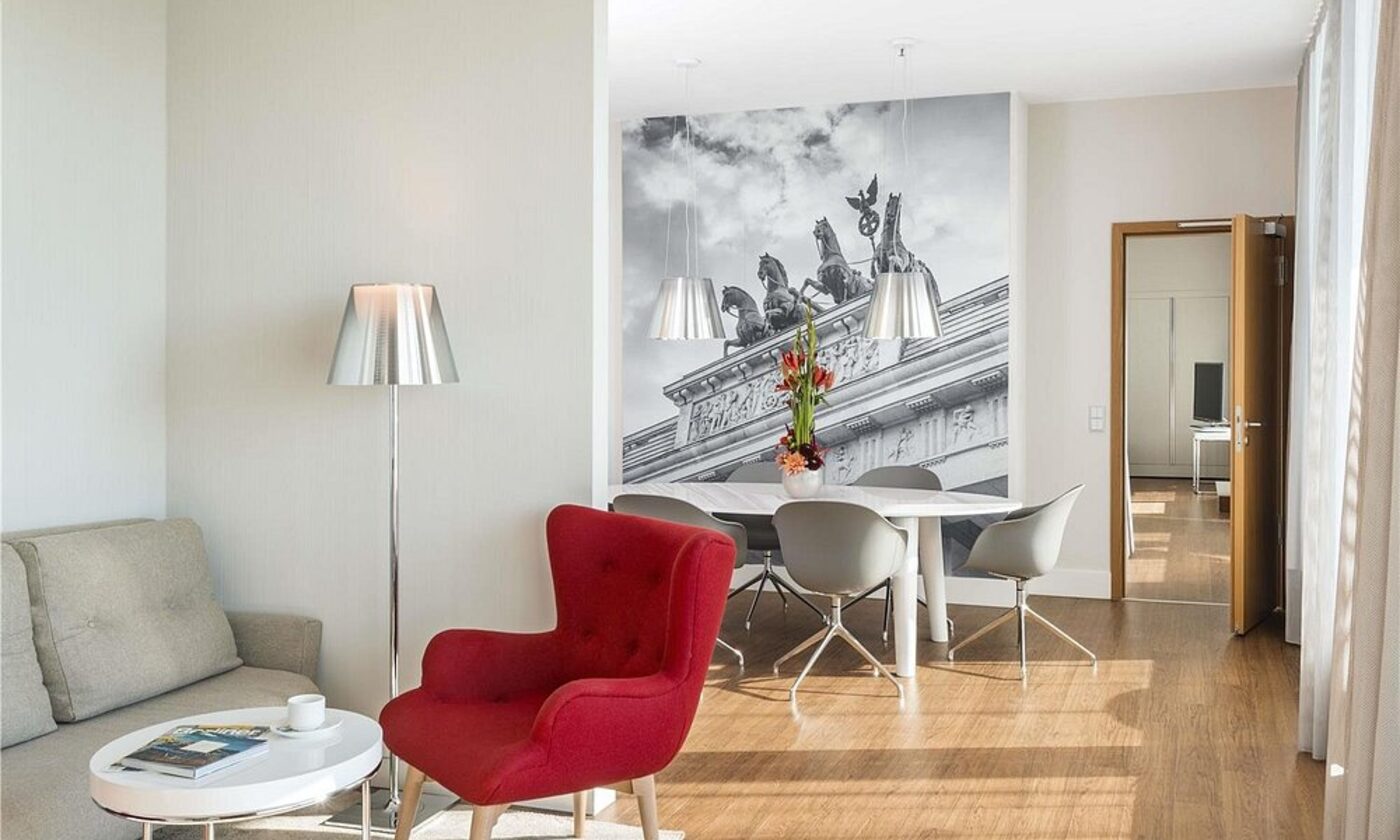 A suite lounge and dining area with a Brandenburg Gate mural