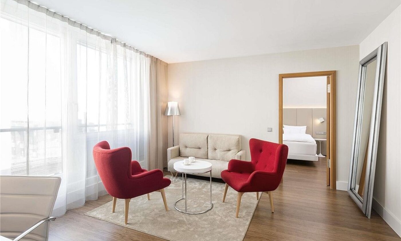 A suite living area with red accent chairs