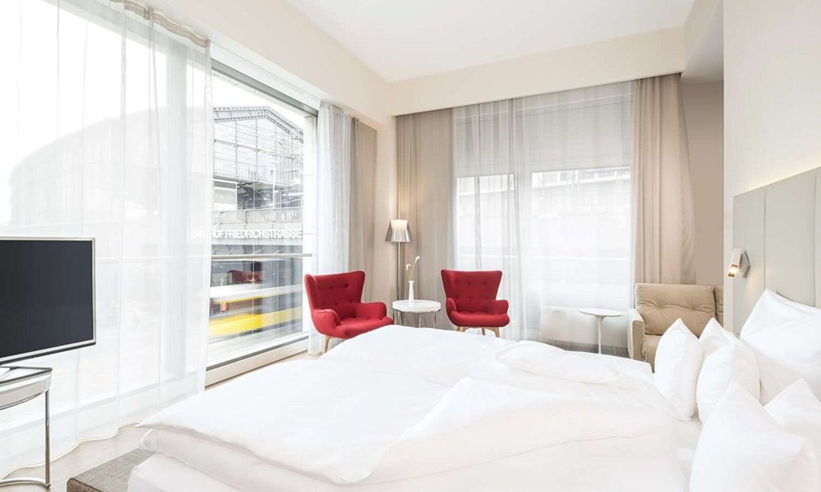 A room window at NH Collection Berlin Mitte Friedrichstrasse framing the Bahnhof Friedrichstrasse station just outside