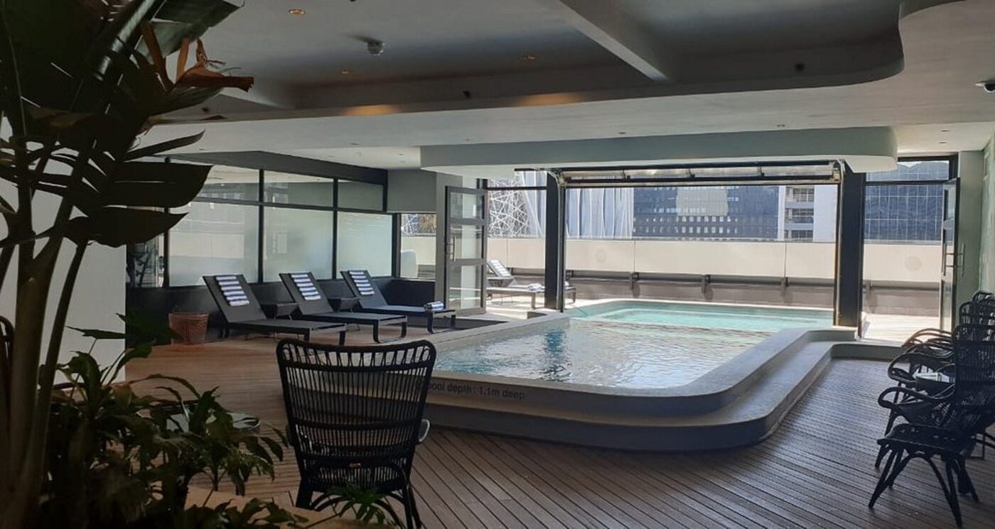 The rooftop pool deck with loungers and city views