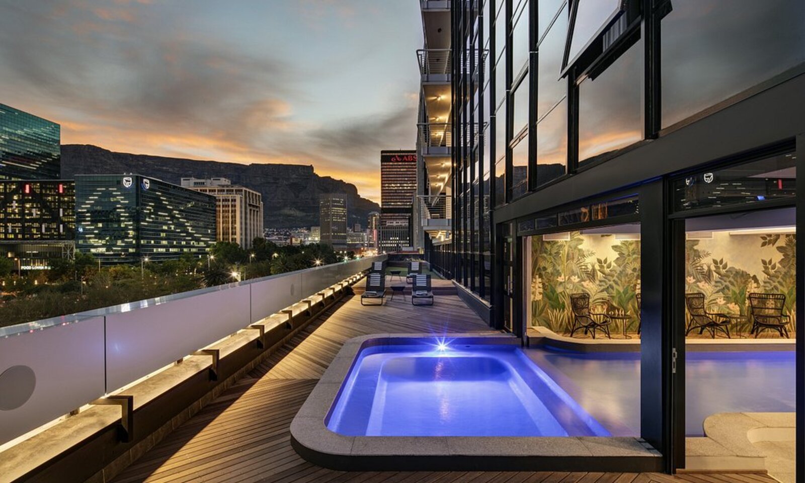 The Onyx Hotel's rooftop plunge pool at dusk with Table Mountain and the city skyline behind