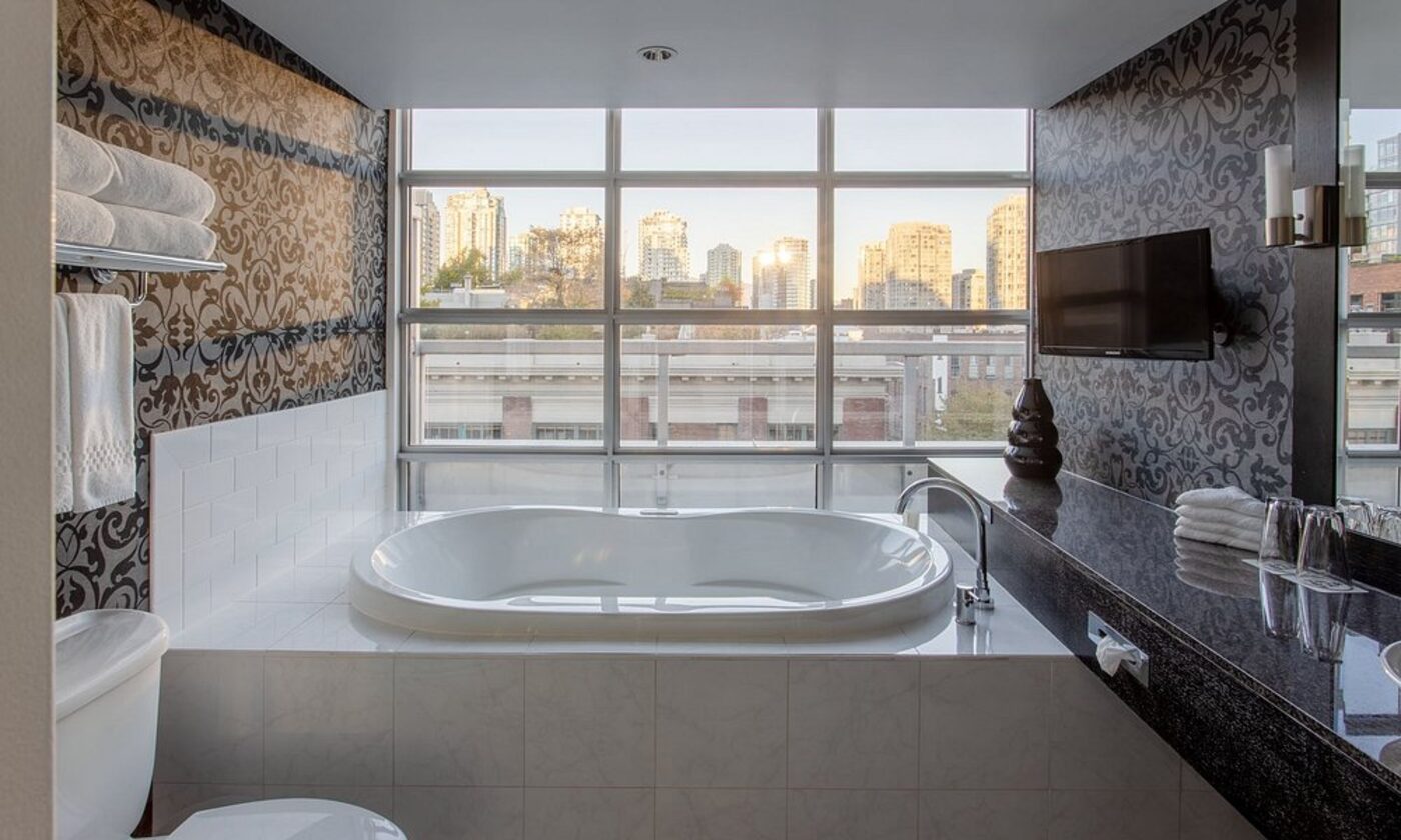 A bathroom with a soaking tub and city views