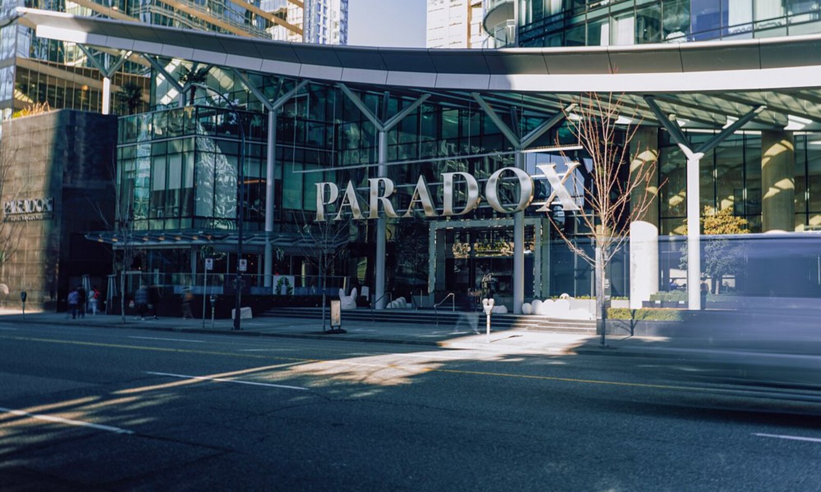 A glass hotel entrance and facade on a city street