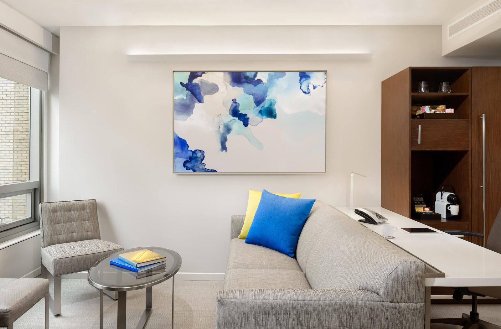 A light-filled seating area with original artwork and a Nespresso corner