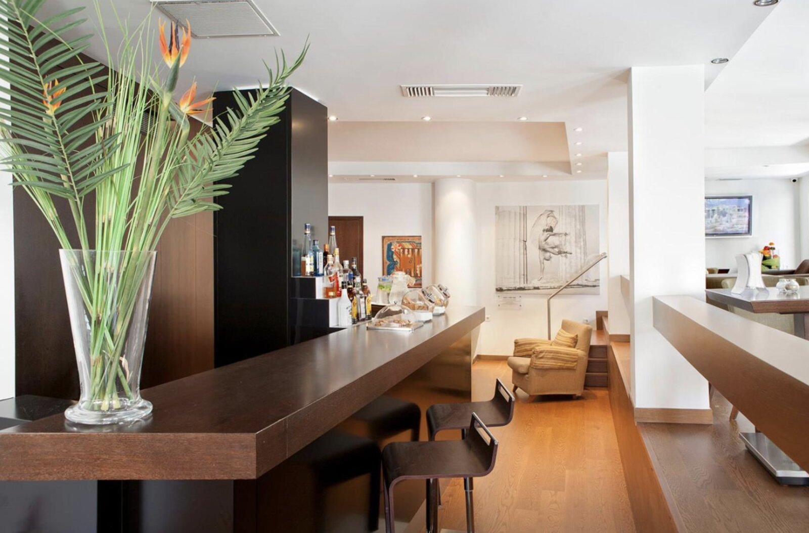 The hotel bar at Plaka Hotel, with tall windows onto the street and framed artwork