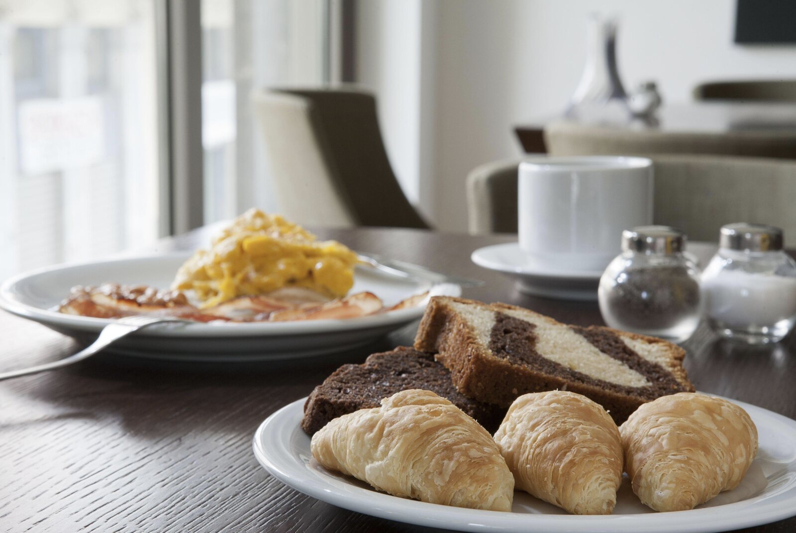 A breakfast spread of croissants, cake and scrambled eggs at Plaka Hotel