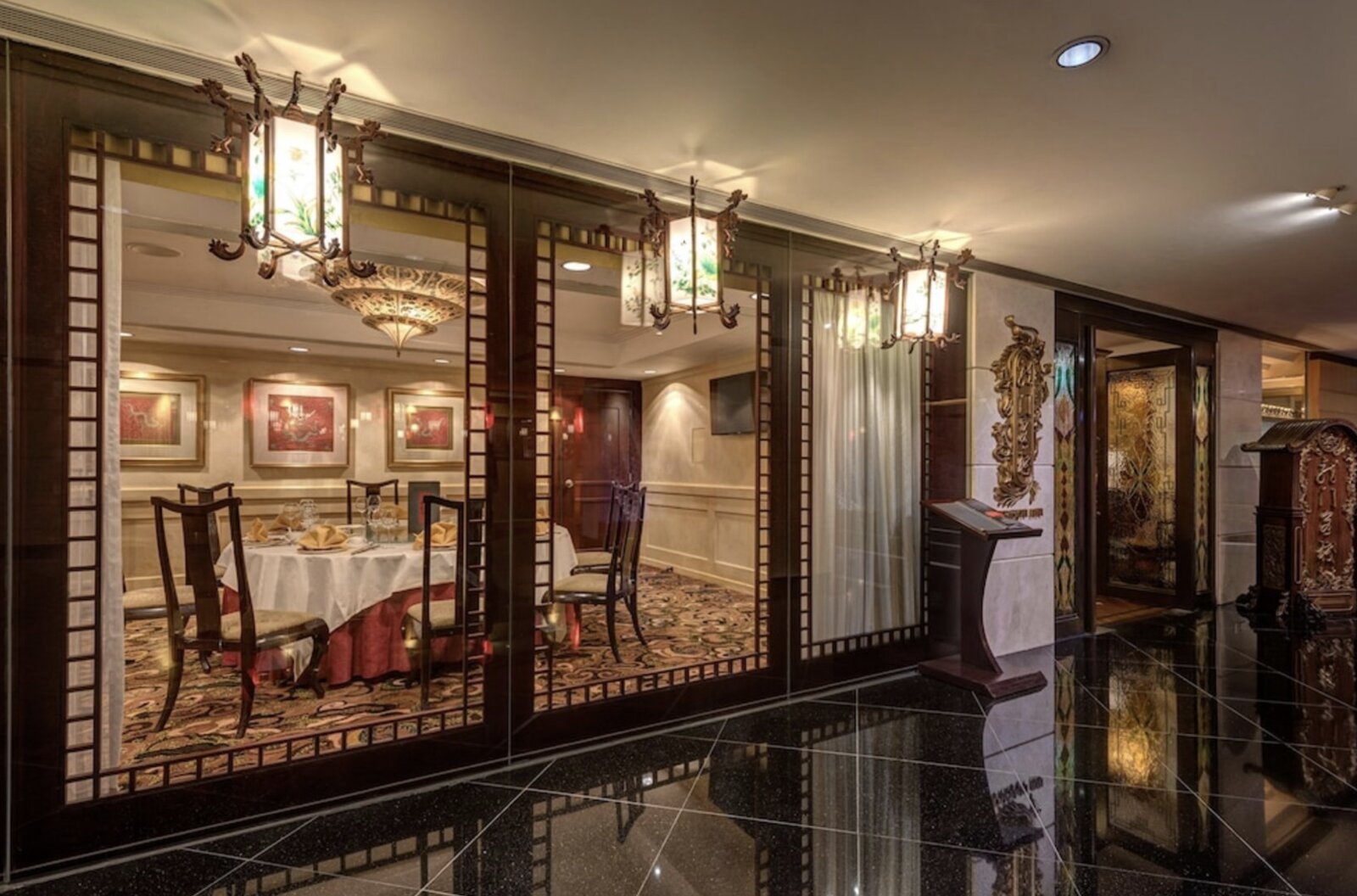 An elegant private Chinese dining room at Regal Airport Hotel, seen through glass panels