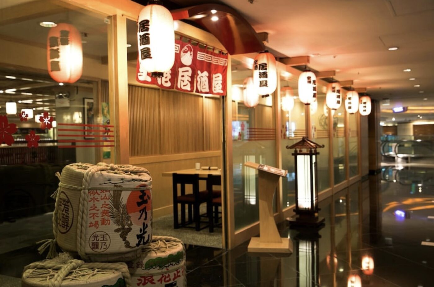 A Japanese izakaya restaurant at Regal Airport Hotel, lit by paper lanterns and sake barrels