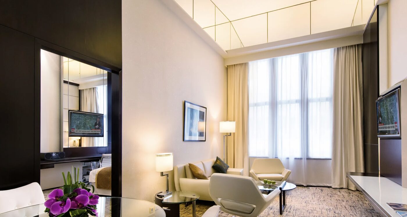 The living area of a suite at Regal Airport Hotel, with tall curtained windows