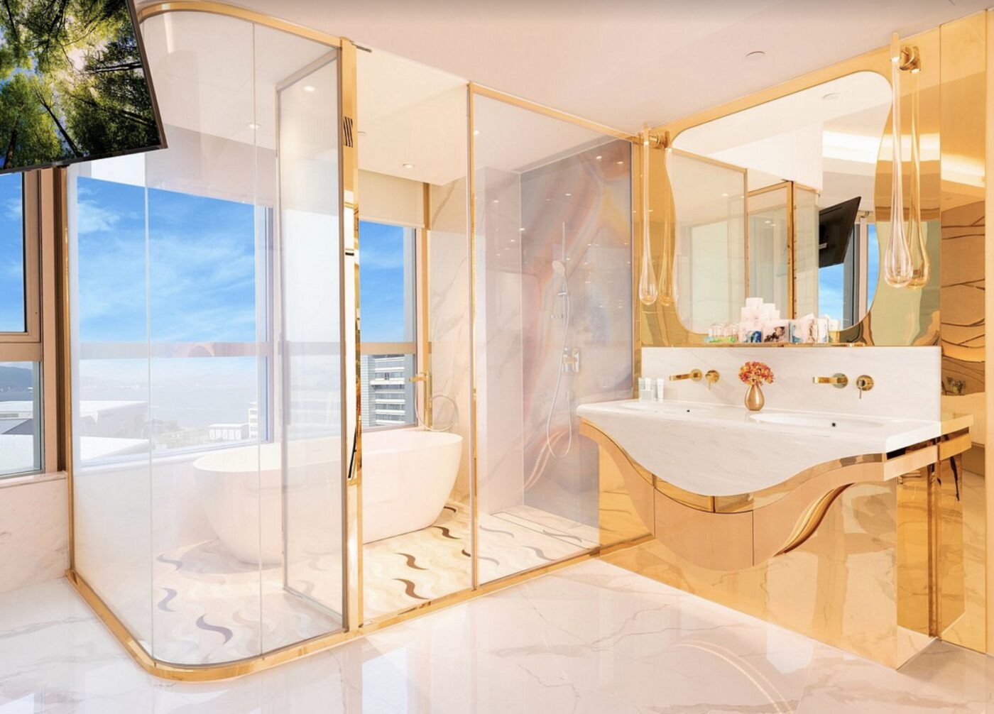 A gold-trimmed bathroom at Regala Skycity Hotel with a freestanding tub and dual vanity