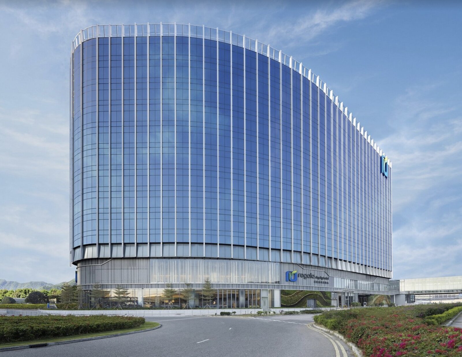 The curved blue-glass facade of Regala Skycity Hotel near Hong Kong International Airport