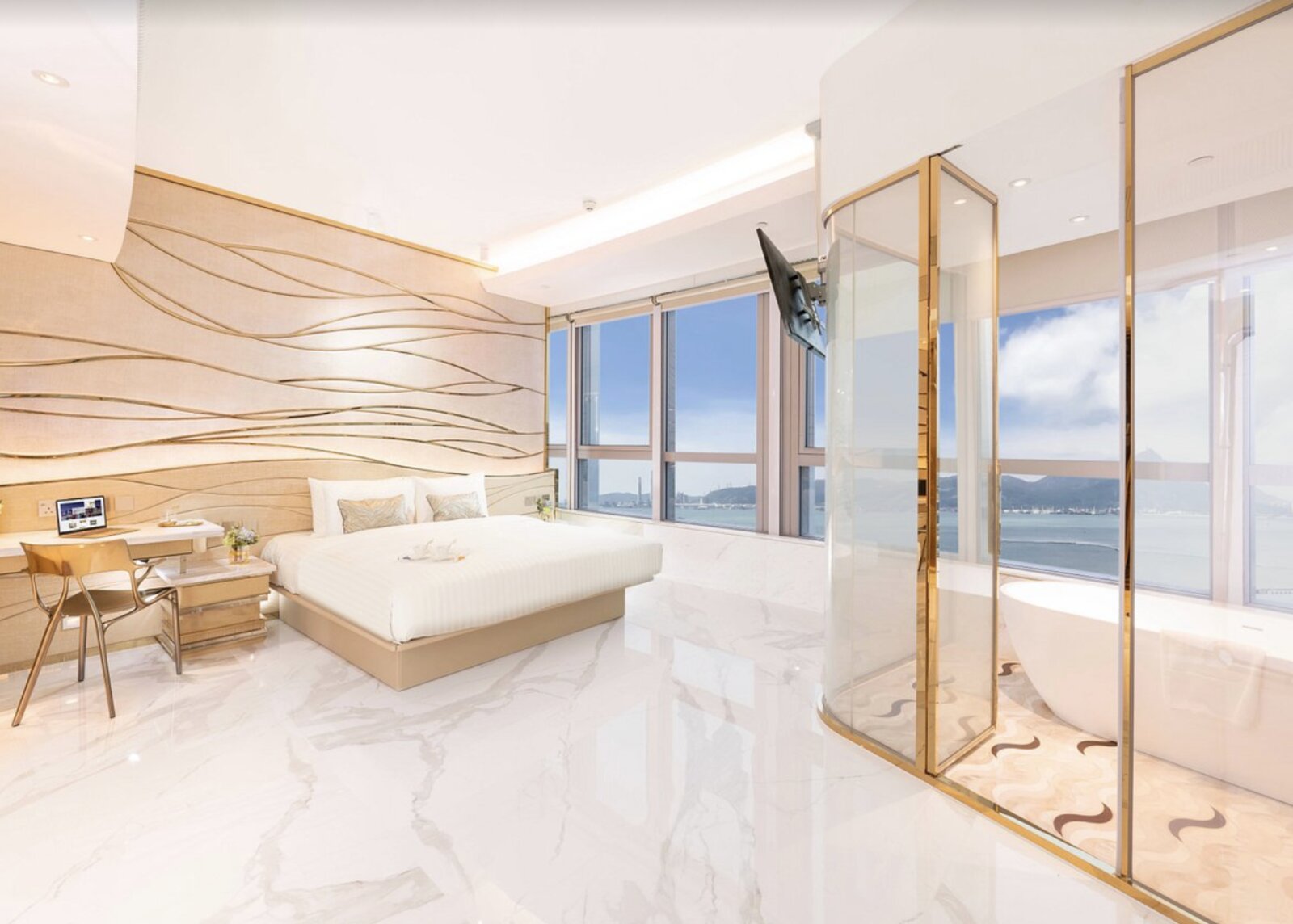 A gold-accented suite bedroom at Regala Skycity Hotel with a freestanding tub and harbour view