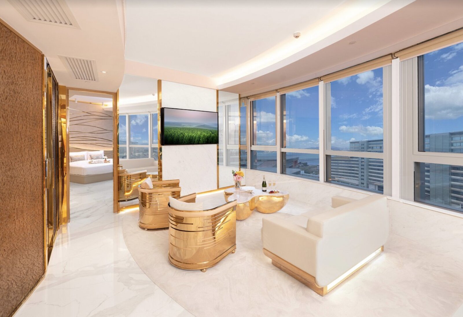 The living area of a suite at Regala Skycity Hotel, with gold furnishings and a wide view over the airport surroundings