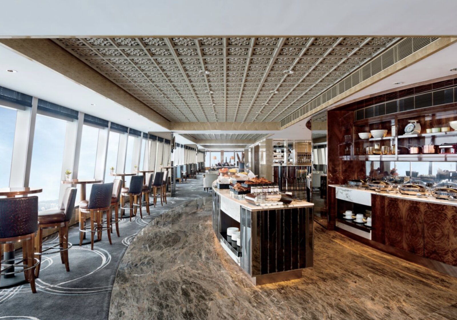 A breakfast lounge high above Hong Kong at The Ritz-Carlton, with a buffet spread and floor-to-ceiling windows
