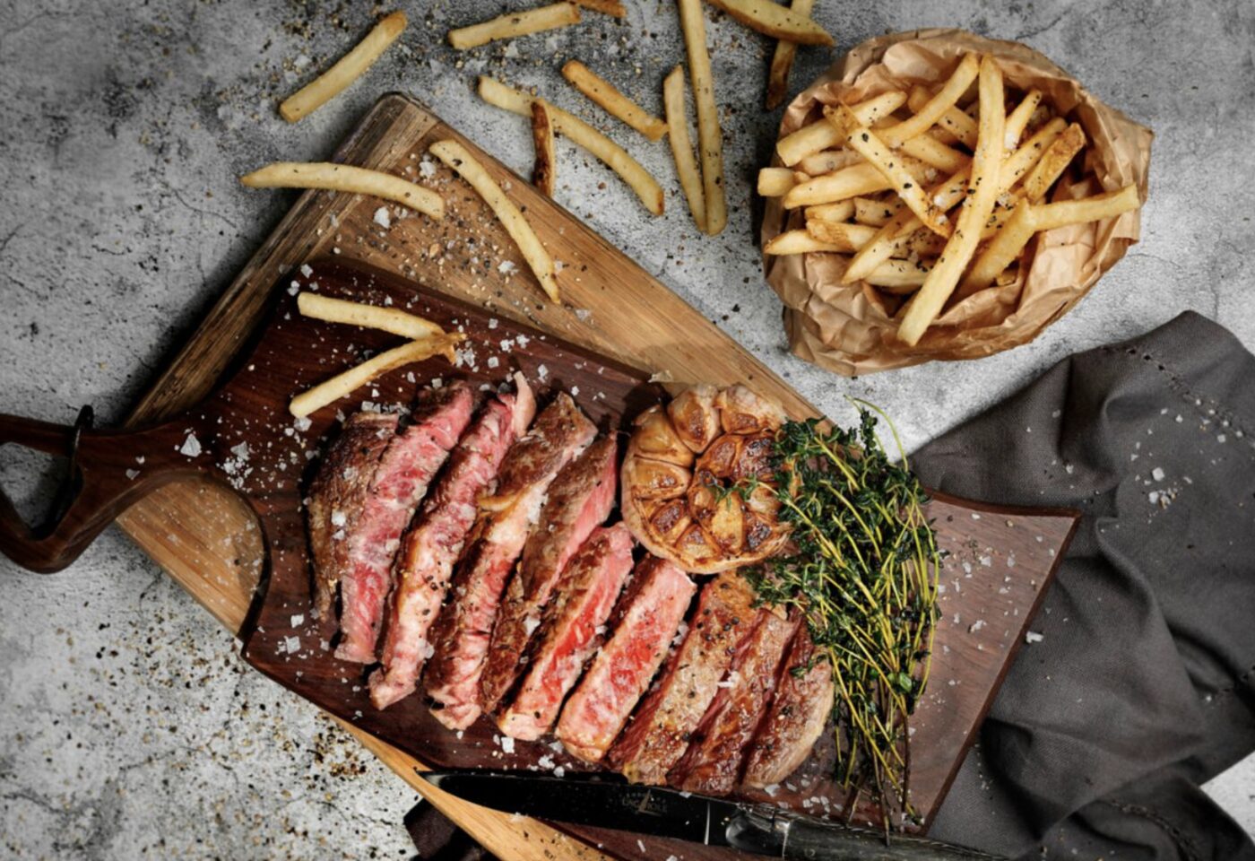 A sliced steak with roasted garlic, thyme and a side of fries at one of the hotel's restaurants