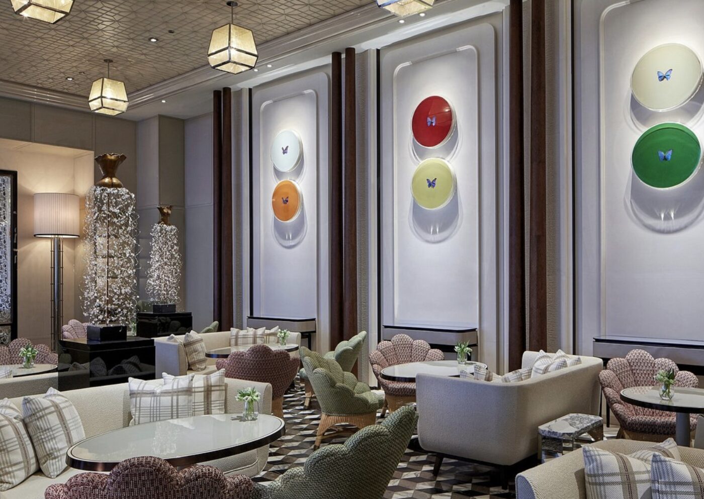 A lounge at Rosewood Hong Kong decorated with butterfly-specimen wall art in a row of colourful discs