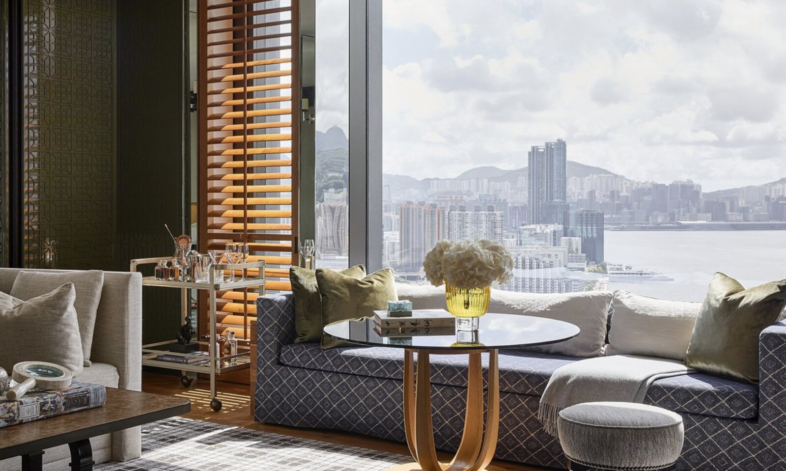 A suite lounge at Rosewood Hong Kong with a wide window looking across the harbour to Kowloon