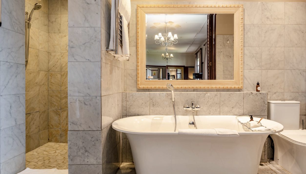 A marble bathroom with a freestanding tub and chandelier