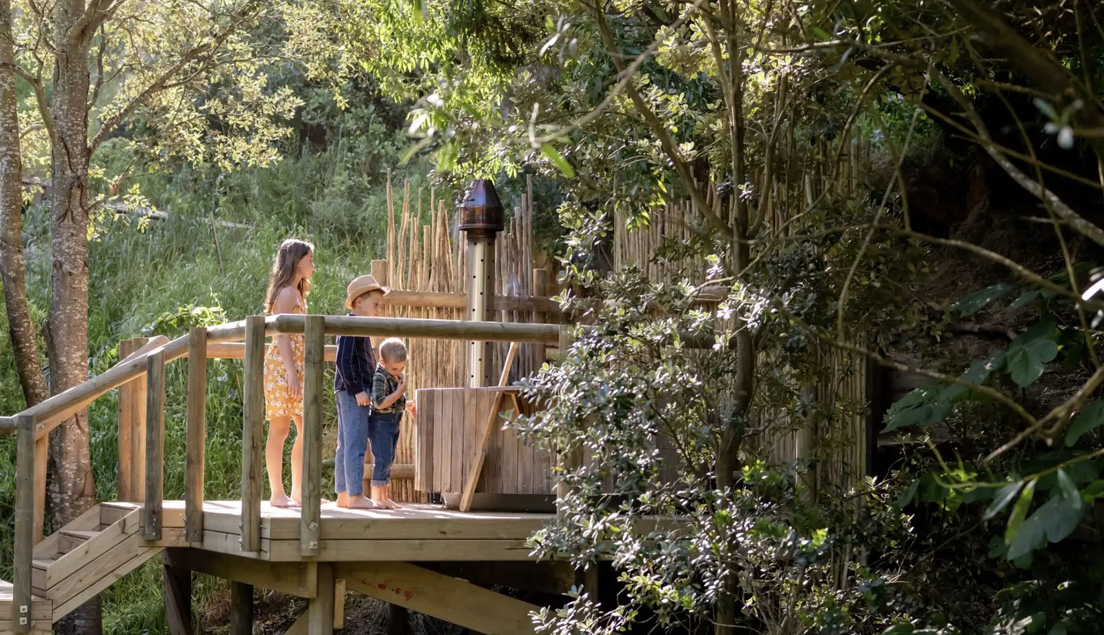 Children exploring the timber play deck in the villa's leafy garden
